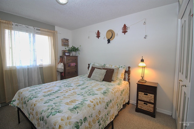 bedroom featuring baseboards, a textured ceiling, a closet, and carpet flooring