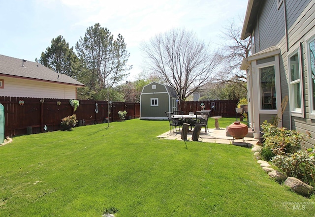 view of yard with a storage unit, an outdoor structure, a fenced backyard, and a patio area