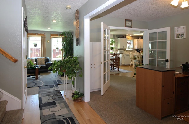 interior space featuring light wood finished floors, a textured ceiling, stairway, and french doors