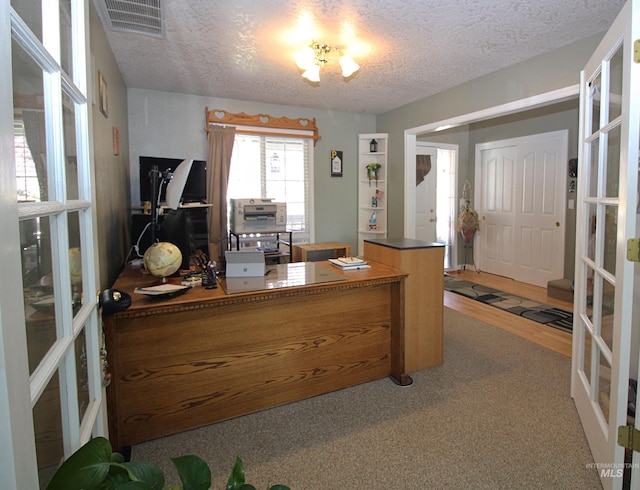 office featuring a textured ceiling, french doors, and visible vents
