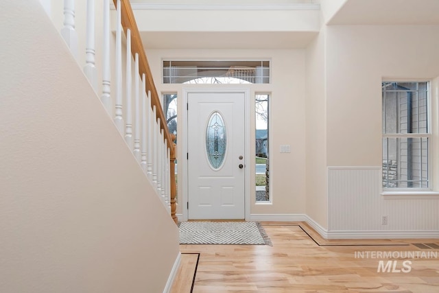 foyer with wainscoting, wood finished floors, and visible vents