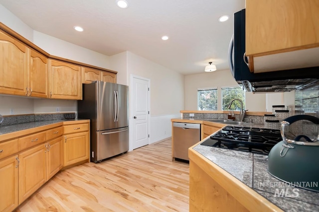 kitchen featuring tile counters, appliances with stainless steel finishes, light wood-style floors, a sink, and recessed lighting