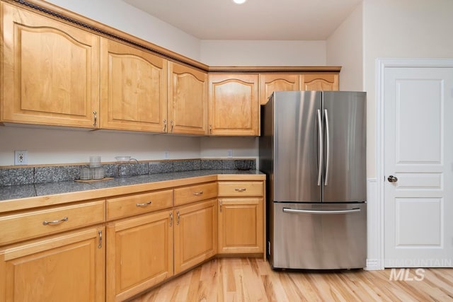 kitchen featuring freestanding refrigerator, light wood-style flooring, and tile countertops