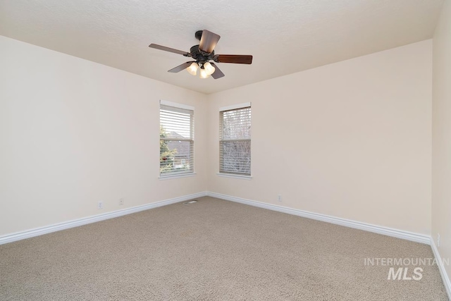 unfurnished room with a textured ceiling, carpet flooring, a ceiling fan, and baseboards