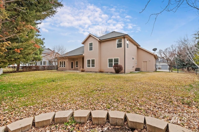 back of property with fence and a lawn