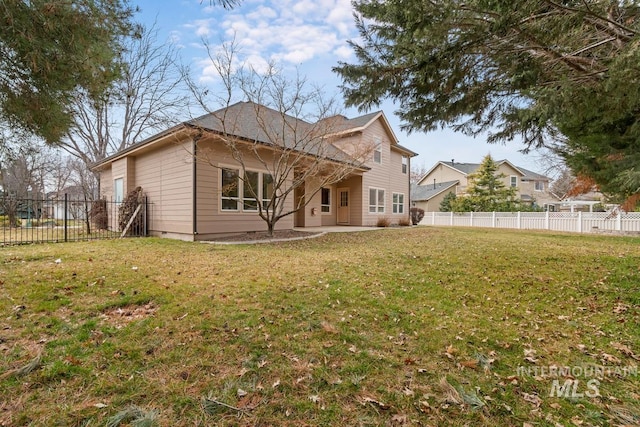 back of house with a patio, a lawn, and a fenced backyard