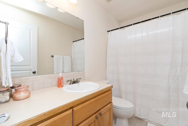 full bathroom featuring tile patterned flooring, toilet, vanity, and decorative backsplash