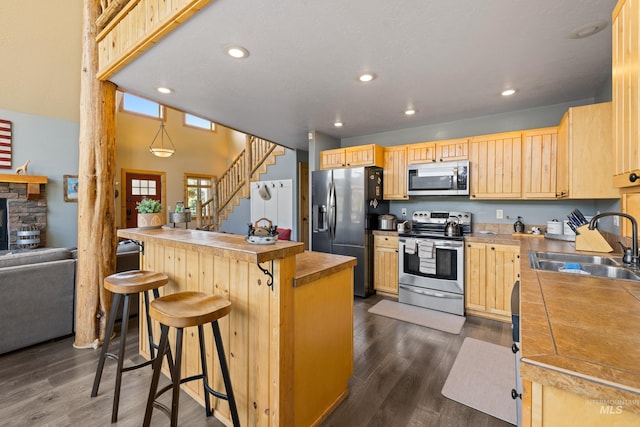 1017 Potts Dr, Mccall, ID 83638 - kitchen with stainless steel appliances, a sink, light brown cabinetry, a breakfast bar, and recessed lighting