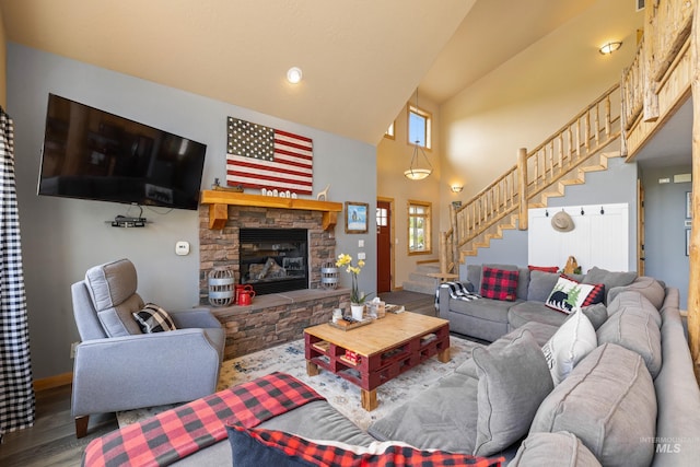 1017 Potts Dr, Mccall, ID 83638 - living room featuring stairway, high vaulted ceiling, wood finished floors, a stone fireplace, and baseboards