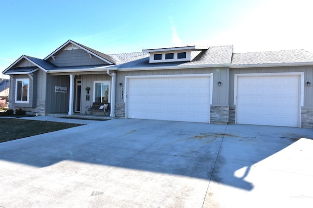 view of front of house featuring a garage, stone siding, driveway, and board and batten siding