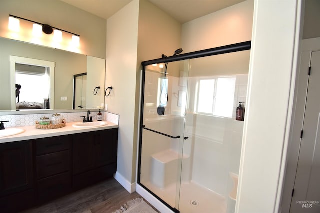 bathroom with connected bathroom, a sink, a shower stall, and double vanity