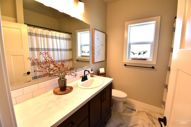 bathroom featuring marble finish floor, visible vents, toilet, vanity, and baseboards