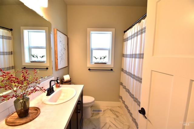 bathroom featuring toilet, visible vents, vanity, baseboards, and marble finish floor