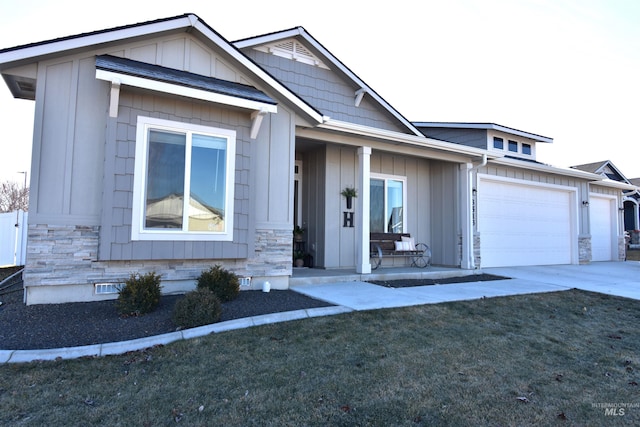 view of front of home with an attached garage, stone siding, concrete driveway, crawl space, and board and batten siding