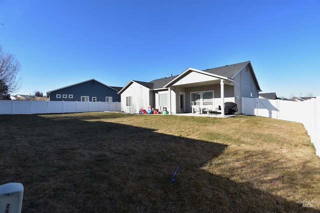 back of house featuring a yard, a patio, and a fenced backyard