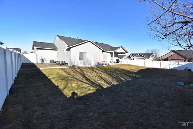 back of property with a fenced backyard, a residential view, and a yard