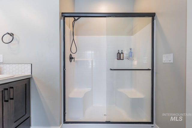 bathroom featuring a shower stall and vanity