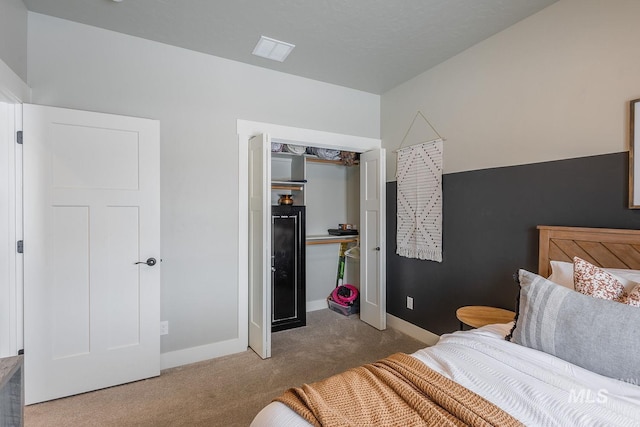 carpeted bedroom featuring a closet and baseboards