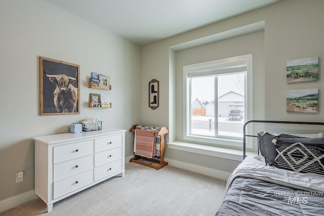 bedroom with baseboards and light colored carpet