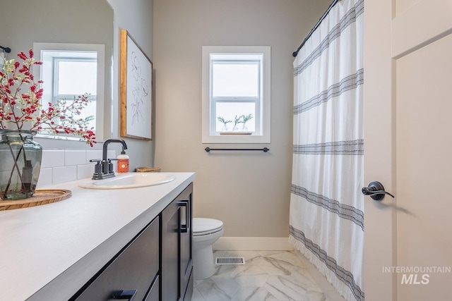 bathroom with a healthy amount of sunlight, visible vents, toilet, and vanity