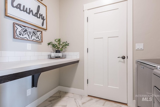 interior space with marble finish floor, baseboards, and separate washer and dryer