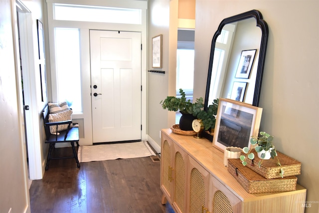 foyer with dark wood-type flooring and baseboards