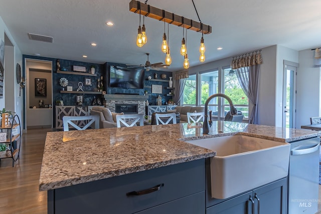 9473 W Suttle Lake Dr, Boise, ID 83714 - kitchen with a sink, ceiling fan, a stone fireplace, dishwashing machine, and stone counters