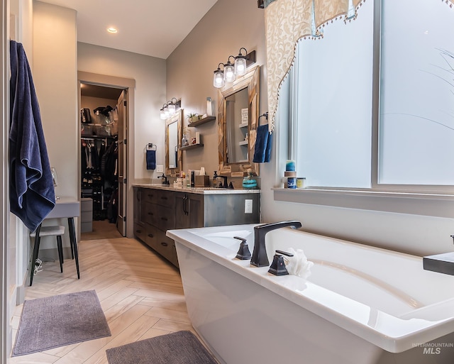 9473 W Suttle Lake Dr, Boise, ID 83714 - bathroom with a soaking tub, vanity, a spacious closet, and recessed lighting
