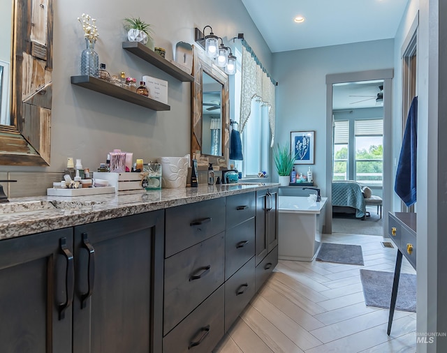 9473 W Suttle Lake Dr, Boise, ID 83714 - ensuite bathroom with double vanity, a ceiling fan, recessed lighting, and a bath