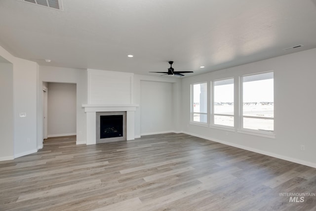 8196 E Red Horse St, Nampa, ID 83687 - unfurnished living room with light wood-type flooring, visible vents, a ceiling fan, and a large fireplace