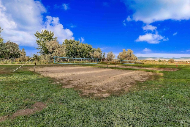 surrounding community featuring a yard, a mountain view, a rural view, and volleyball court