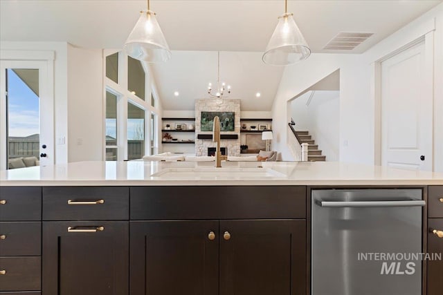 kitchen with sink, pendant lighting, a notable chandelier, and stainless steel dishwasher