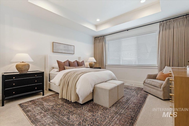 bedroom featuring a raised ceiling and carpet floors