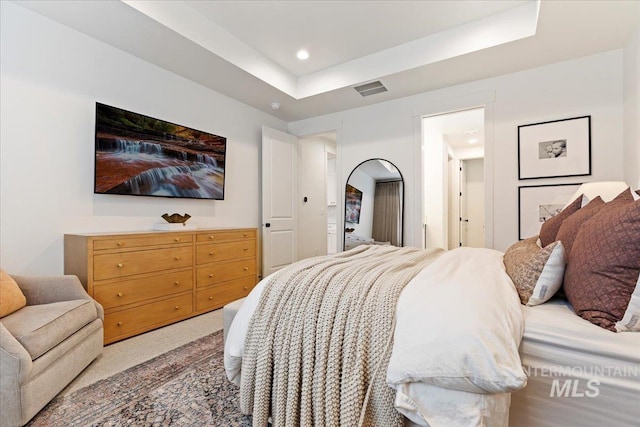 bedroom featuring a raised ceiling and carpet flooring