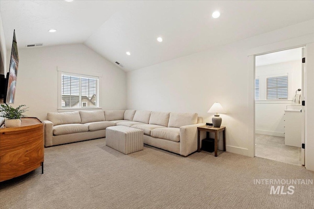 carpeted living room with vaulted ceiling