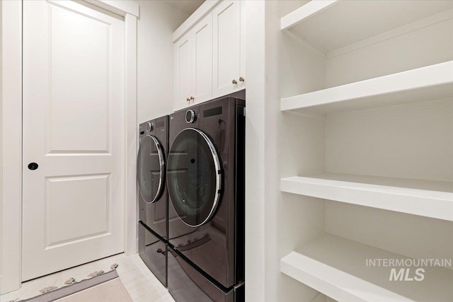 laundry area featuring cabinets, washing machine and dryer, and crown molding