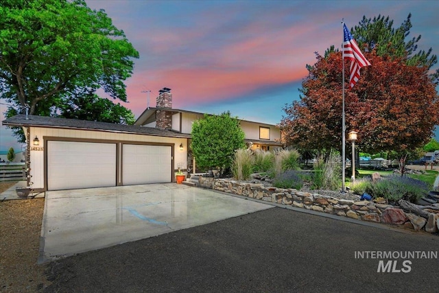 14525 Woosley, Nampa, ID 83651 - view of front of home with driveway, a chimney, and an attached garage