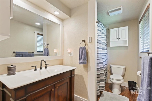 14525 Woosley, Nampa, ID 83651 - full bathroom featuring toilet, vanity, wood finished floors, baseboards, and curtained shower