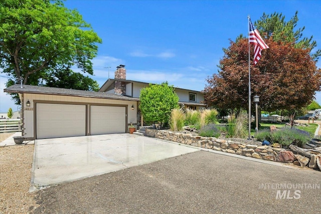 14525 Woosley, Nampa, ID 83651 - obstructed view of property with an attached garage, driveway, and a chimney