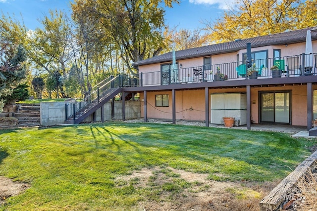 rear view of house featuring a wooden deck and a yard