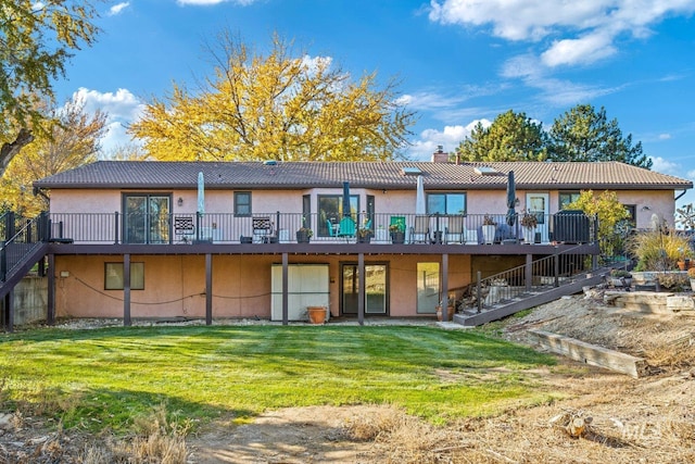 rear view of house with a wooden deck and a yard