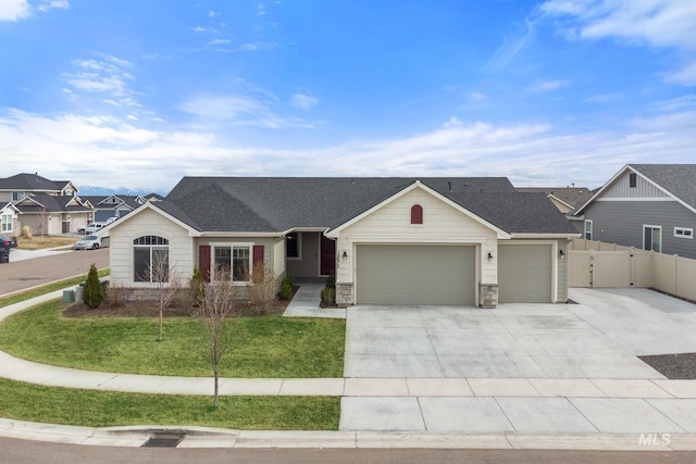 ranch-style home with driveway, fence, a front yard, a shingled roof, and a garage