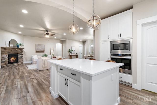 kitchen with light wood finished floors, recessed lighting, ceiling fan, stainless steel appliances, and a center island