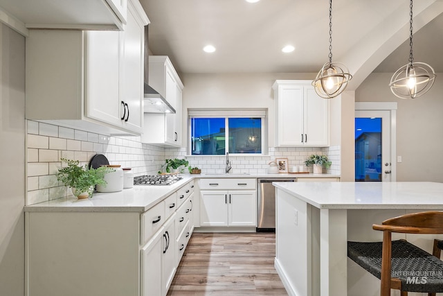 kitchen featuring tasteful backsplash, a breakfast bar, light wood-style flooring, appliances with stainless steel finishes, and a sink