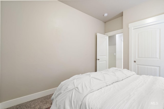 carpeted bedroom featuring baseboards and a closet