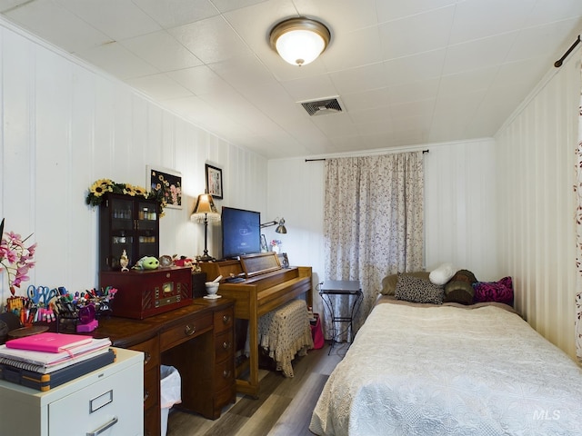 bedroom featuring wood-type flooring and crown molding