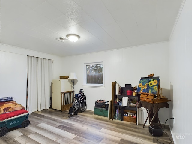 miscellaneous room featuring light hardwood / wood-style floors and crown molding