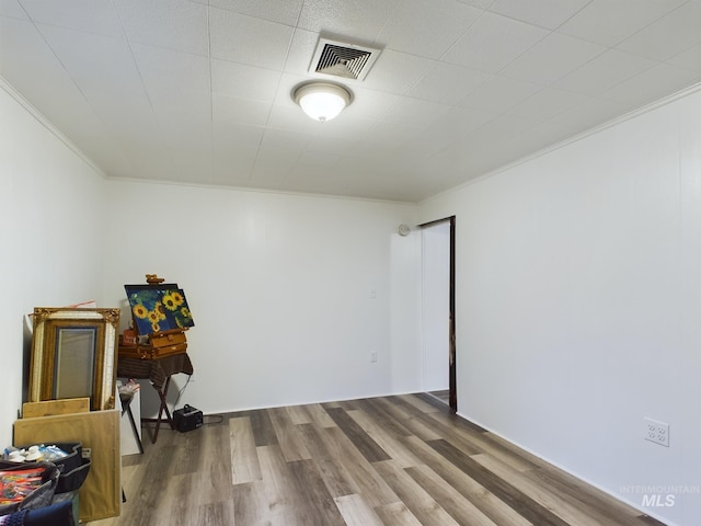 spare room featuring hardwood / wood-style floors and crown molding