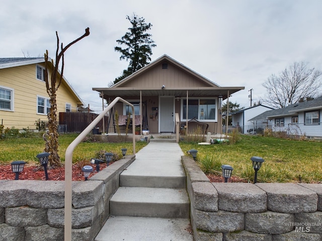 bungalow-style home featuring covered porch and a front yard