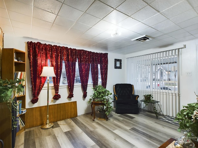 sitting room with a paneled ceiling and hardwood / wood-style floors